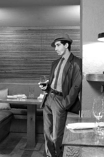 Gangster with wine Black and white of a gangster type leaning on a wall with a glass of wine in his hand stetner stock pictures, royalty-free photos & images