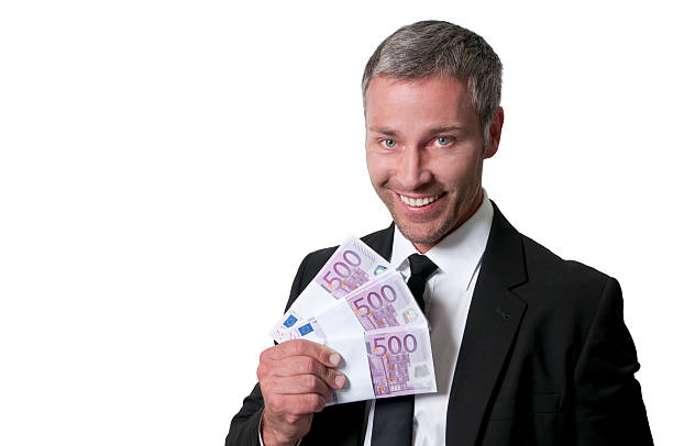 улыбающийся бизнесмен с куча денег - greed currency men happiness стоковые фото и изображения