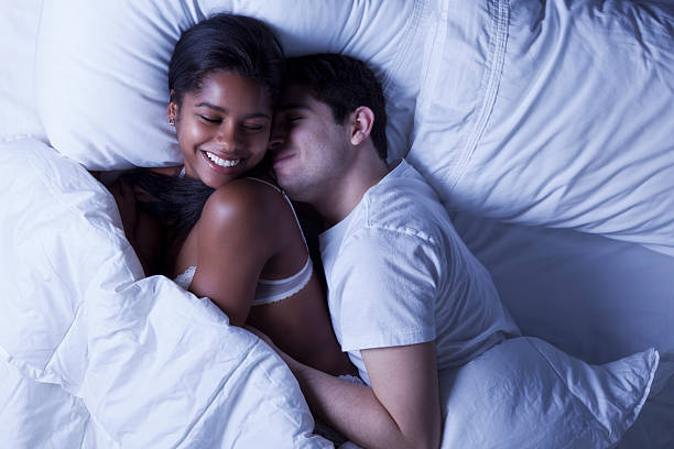 casal jovem feliz na cama - men sensuality photography high angle view imagens e fotografias de stock