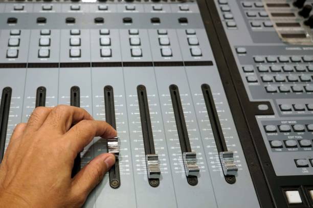 ingénieur du son travaillant sur la console de mixage, gros plan sur les mains en train de régler un fader. - faders photos et images de collection