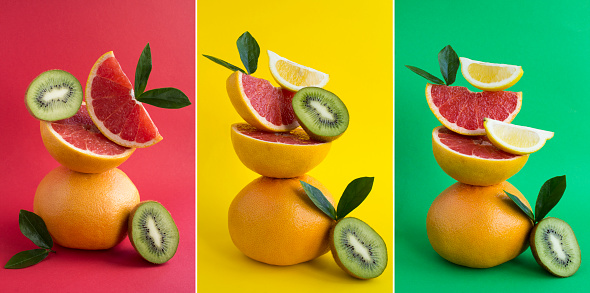 Collage. Pyramid of grapefruit, lemon and kiwi in balance  on the colored background. Close-up.