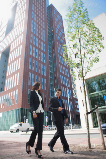 two young business people walking in front of their office