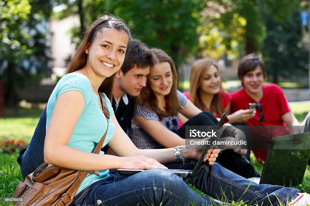 Group of college students smiling and studying on campus Group of college students studying at campus Group Of People Stock Photo