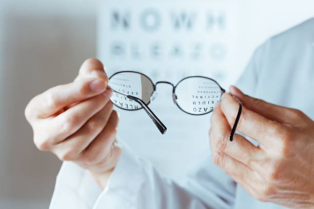 istock Optometrist Holding Glasses Conducting Eye Chart Examination Hz 184275680