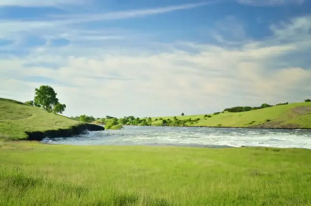 "Looks like a tranquil scene as the Missouri river flows from the Oahe dam toward Pierre, South Dakota. Further down stream, towns are flooded and lives distressed."