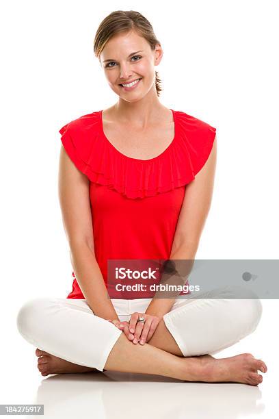 Portrait Of A Smiling Lady In A Red Top With Legs Crossed Stock Photo - Download Image Now
