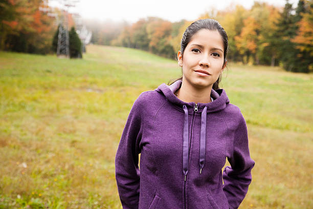 Young Latina beauty hiking in Fall Nature Young Latina beauty hiking down a ski hill in Autumn. She is wearing a purple cotton jacket. montérégie photos stock pictures, royalty-free photos & images