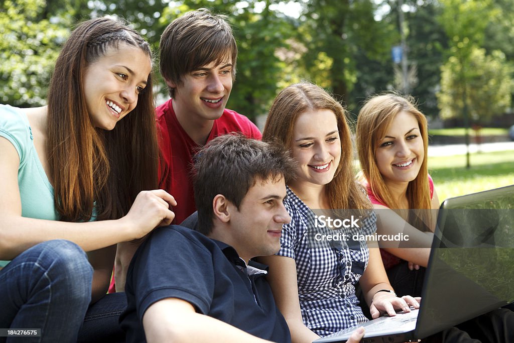 Gruppo di studenti universitari, utilizzando computer portatile all'aperto - Foto stock royalty-free di 20-24 anni