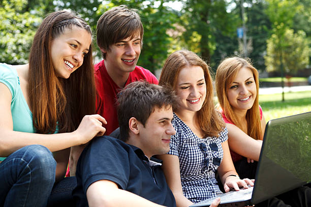 istock Group of college students using laptop outdoors 184276575