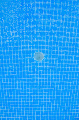 Close up of a swimming pool with a drain in the middle.See more swimming pools here: