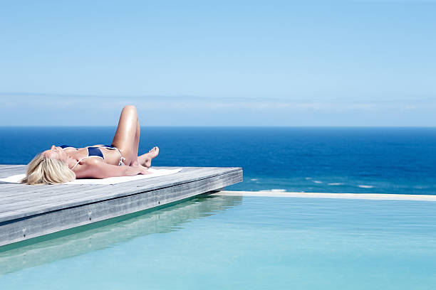 istock Woman relaxing by the poolside 184276735