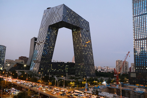 View of the busy elevated road at dusk by the CCTV Headquarters, a 51-floor, 234 mt skyscraper formed out of a pair of conjoined towers in the Beijing Central Business District and serves as the headquarters for China Central Television (CCTV).
