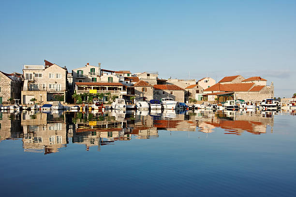 Tribunj cityscape reflected on the sea at sunrise