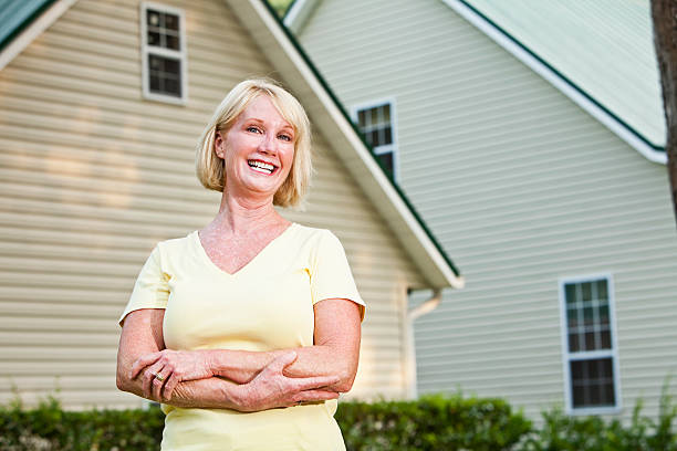 istock Mature woman standing outside home 184277364