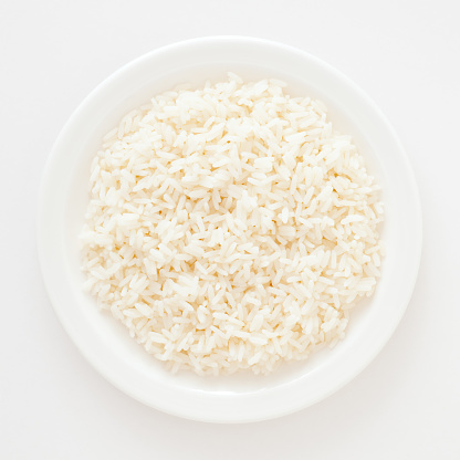 Top view of white dish with boiled white rice on it