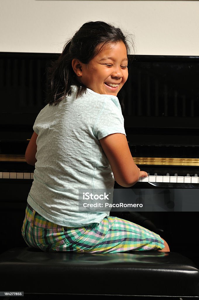 Молодая девушка giggling на пиани�но - Стоковые фото Девочки роялти-фри