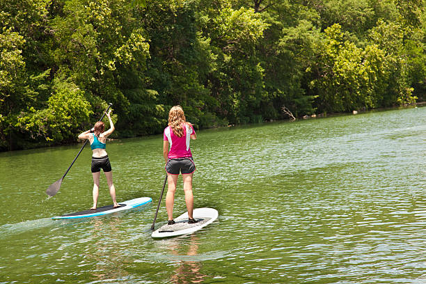 istock Two Woman Stand Up Paddlers Paddling Down a River 184278075