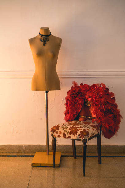 roter modemantel, der auf einem stuhl neben einer leeren schaufensterpuppe hängt. stilvolles und modisches konzept - owner embroidery small business indoors stock-fotos und bilder