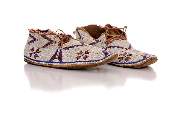 A pair of beautiful rare antique Native American hand beaded moccasins on white.