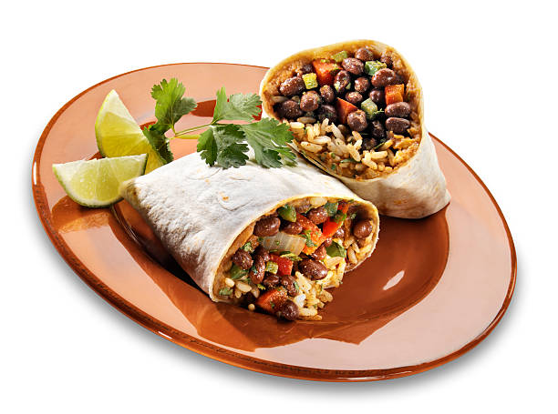 Black Bean Burrito on white "Single serving of a Black Bean burrito with black bean mixture, rice and refried bean rolled up and cut in half. Served with a wedge of lime. Drop shadow created in photoshop." burrito photos stock pictures, royalty-free photos & images