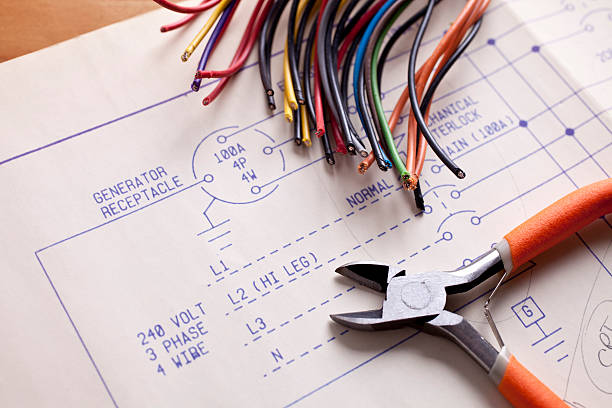 Electrical Wiring with wire cutters and blueprints stock photo