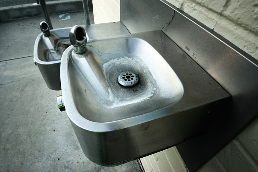 Classic American stainless steel drinking fountains typically found in schools and playgrounds. High quality photo