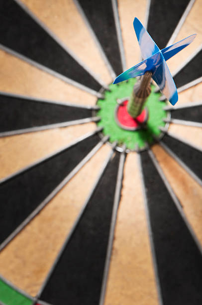 alvo de dardo com um único dart no olho vermelho bulls - target aspirations bulls eye dart imagens e fotografias de stock