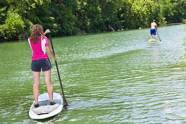 istock Stand Up Paddlers Paddling Down a River 184279415