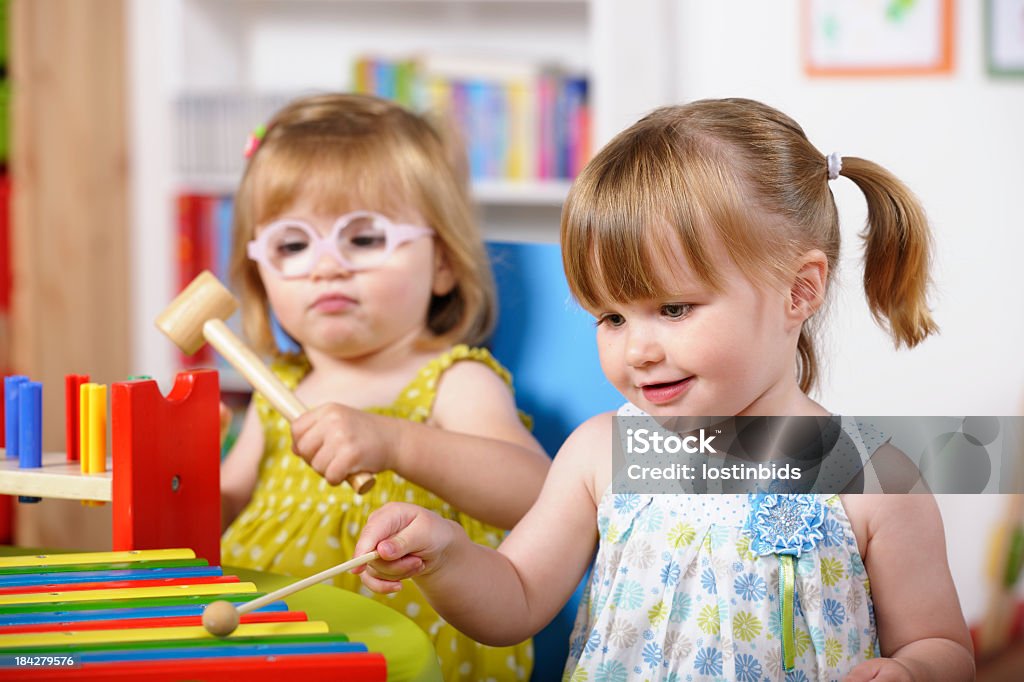 Paar Genießen Sie Musik/Kleinkinder spielen im Kinderzimmer-Ambiente - Lizenzfrei Baby Stock-Foto