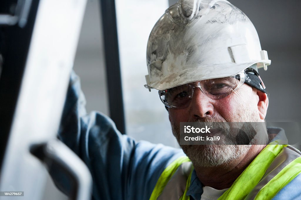 Manual worker in hard hat and safety glasses Industrial worker, 50s, wearing hard hat and safety glasses. Construction Worker Stock Photo