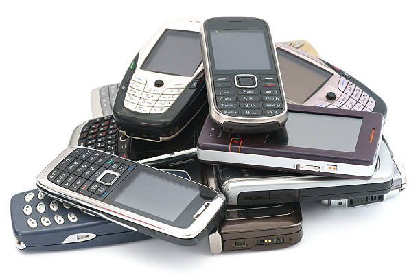 Old used cellphones pile isolated on white