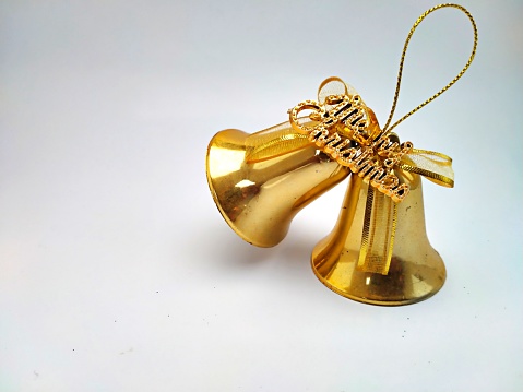 Two golden Christmas bells on a white background