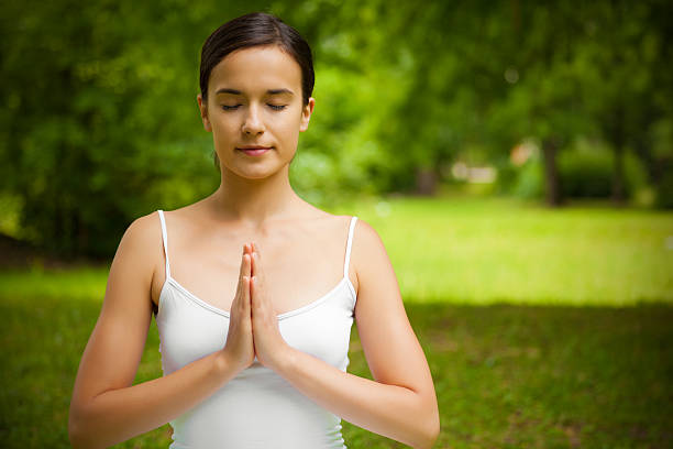 istock Young woman doing meditation outdoor 184280758