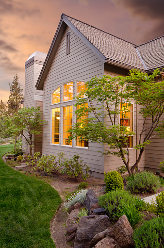 This gives a close up of a twilight exterior of the home and the landscape. 