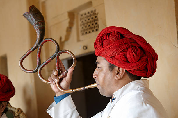 istock Indian musician playing curved trumpet type wind instrument 184281218