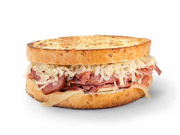 Reuben Sandwich A Classic Grilled Reuben Sandwich on Rye Bread with Swiss Cheese and Sauerkraut with Natural Drop Shadow-Photographed on Hasselblad H3D2-39mb Camera pastrami stock pictures, royalty-free photos & images