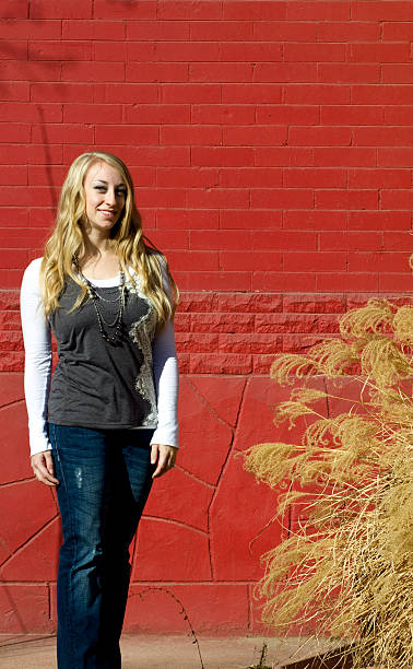 istock Young woman standing by a red wall 184281628