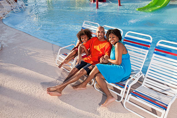 afro-américaine famille sur les chaises longues au bord de la piscine - sc0484 photos et images de collection