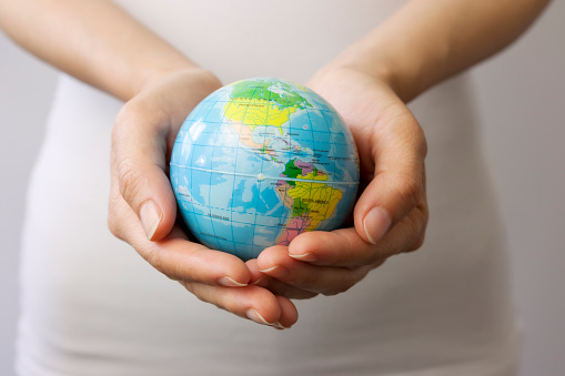 A woman's hands holding a globe.