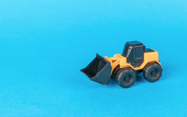 istock A bulldozer with a bucket on wheels on a blue background. 1842827721
