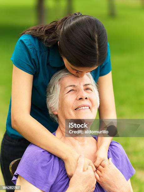 Loving Grandchild Kissing Her Grandmother Stock Photo - Download Image Now - 70-79 Years, Kissing, Young Adult