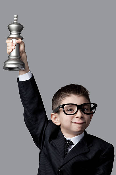 istock Clever little boy lifting chess championship trophy 184282856