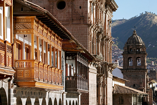 Balconies of colonial buildings with Iglesia La Compania de Jesus (Company of Jesus Church) in background.