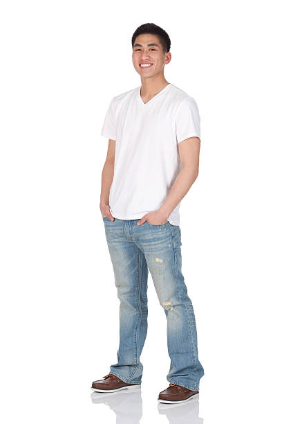 heureux homme debout avec les mains dans les poches - t shirt white men jeans photos et images de collection