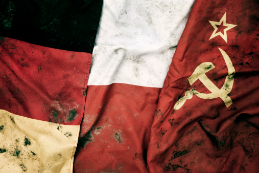 Low key photography of grungy old flags of Germany, Poland and Soviet Union.