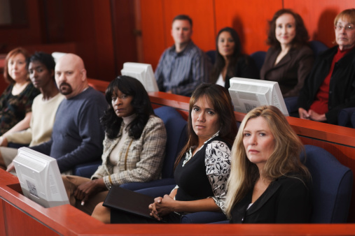 A diverse group of people in the jury box of a courtroom.