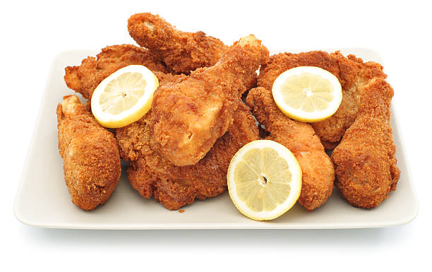 istock Homemade fried chicken legs on plate with lemons 184284940