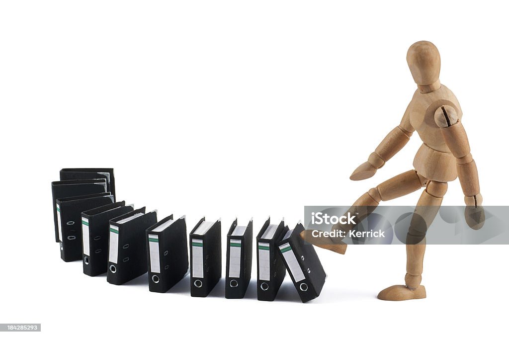 wooden mannequin and domino with folders wooden mannequin kicking folders. Paper stucture visible on folders. Concept for a lot of work, today work, buro, bureaucracy, law, burn out, bore out, workaholic... more of this concept: Artist's Figure Stock Photo