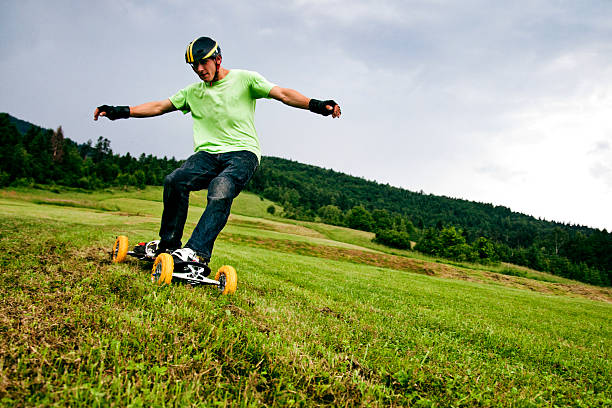 Mountain boarder in action Mountain boarder riding down a hill. kiteboarding stock pictures, royalty-free photos & images