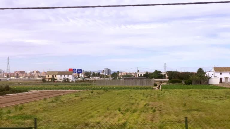 Cultivated fields and orchards seen from train in motion